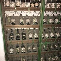 Weinflaschen hinter einem geschmiedeten Gitter
